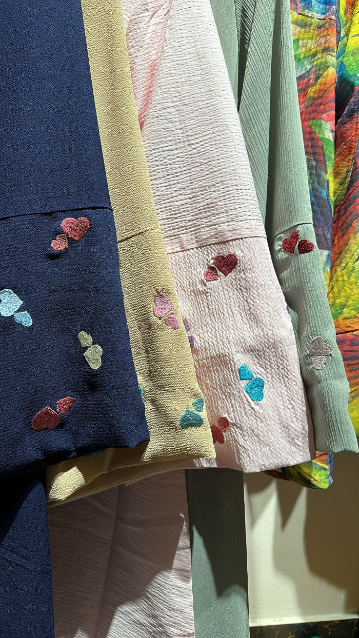 Colorful fabric swatches with embroidered designs on a colorful background