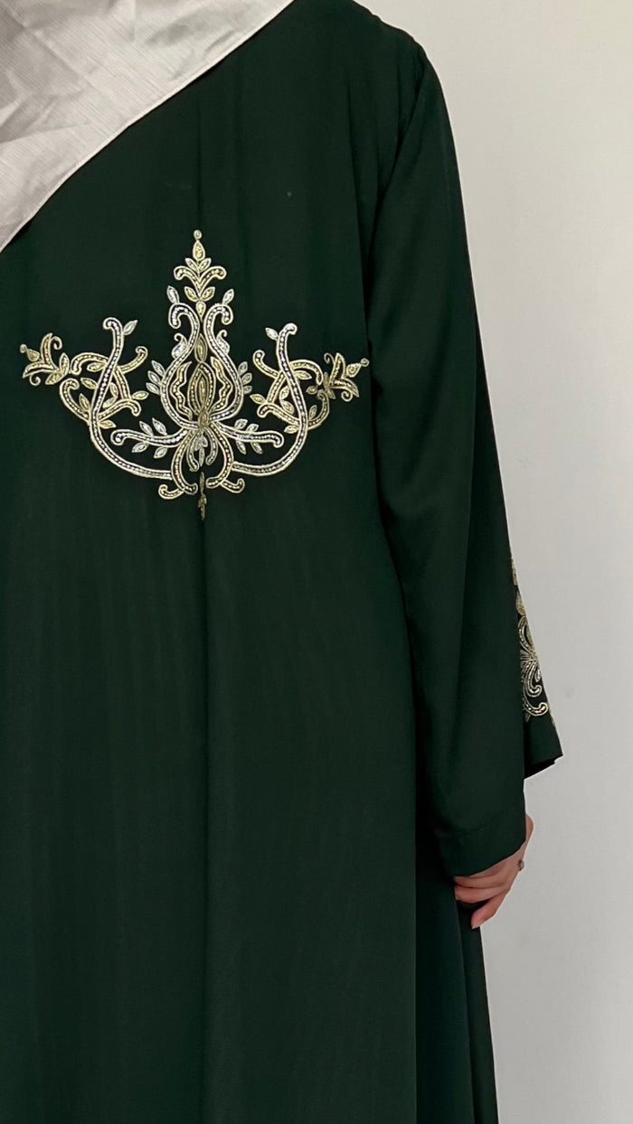 Dark green abaya with gold embroidery on a white background