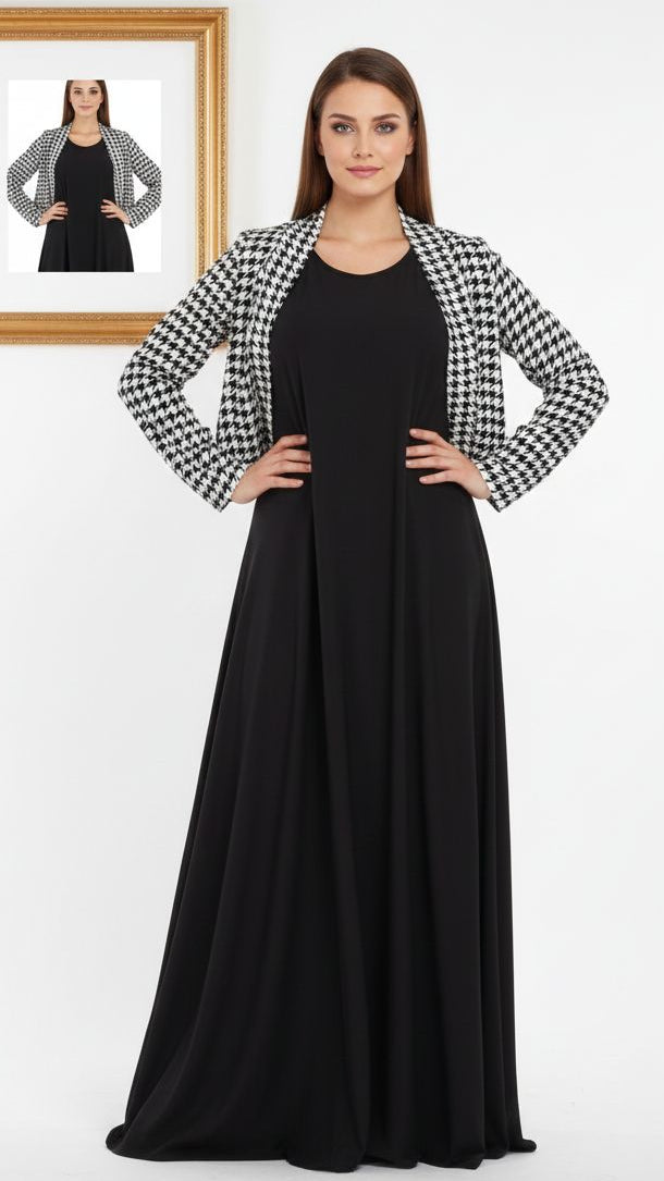 Woman wearing a black dress with a checkered jacket, standing in front of a white background.