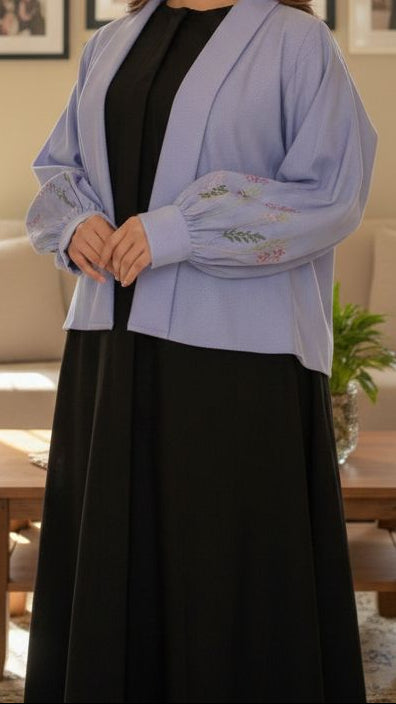 Woman standing in a living room with decor and furniture.