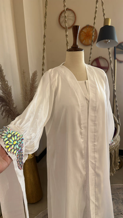 White blouse with embroidered sleeves on a mannequin against a neutral background