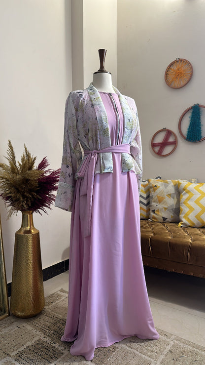 Mannequin wearing a pink dress with a patterned top in a room with a couch and decorative items.