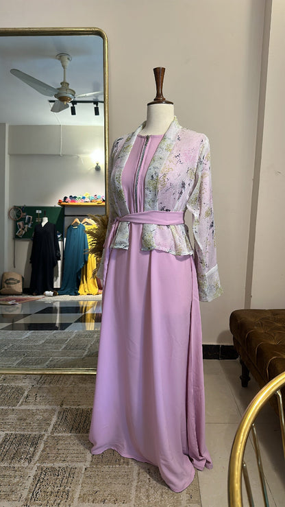 Mannequin wearing a floral top and pink skirt in a room with a mirror and ceiling fan.