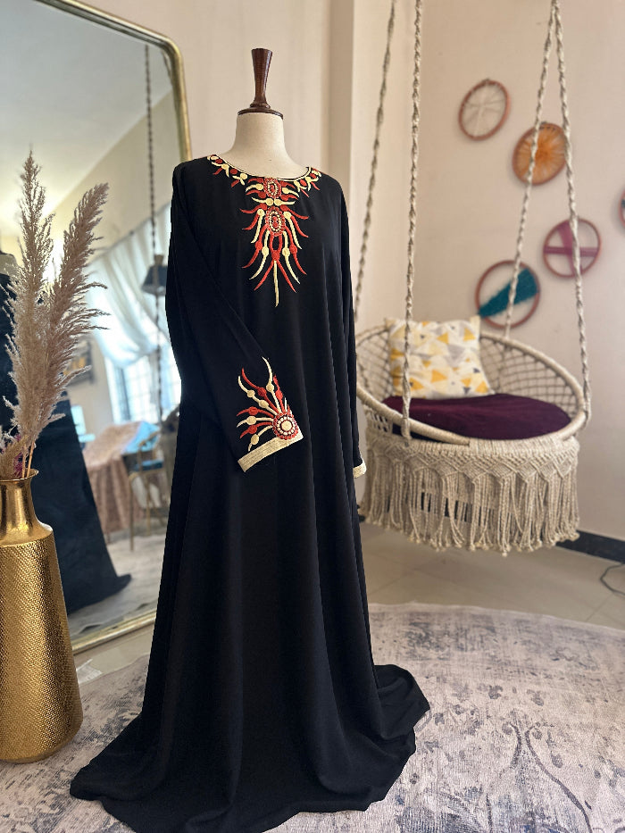 Black embroidered dress on a mannequin in a room with a swing and decorative wall art.