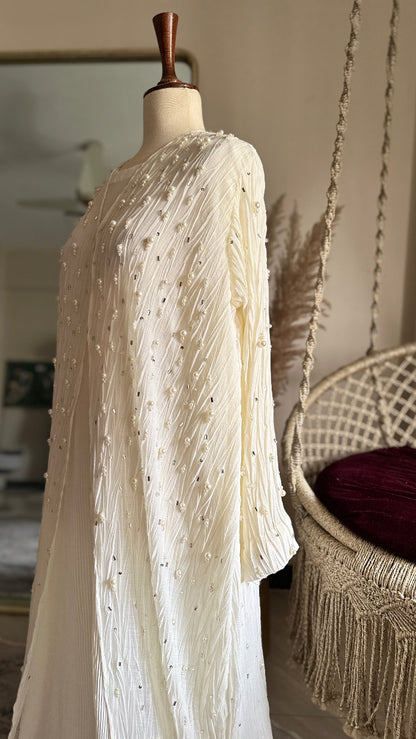Beige dress on a mannequin with a wicker chair in the background