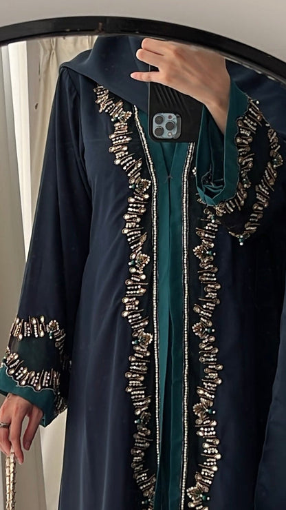 Person wearing a dark blue embroidered dress in front of a mirror.