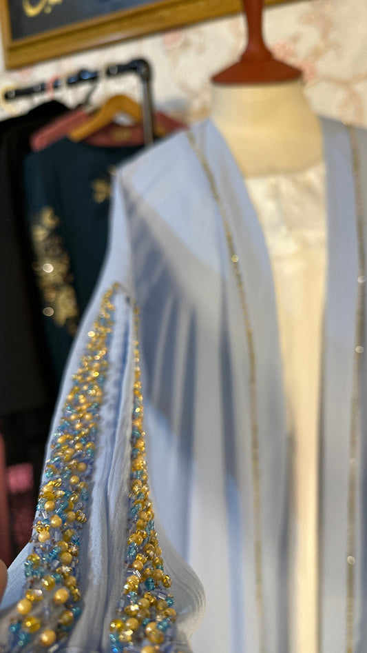 Close-up of a dress with gold embellishments on a floral background
