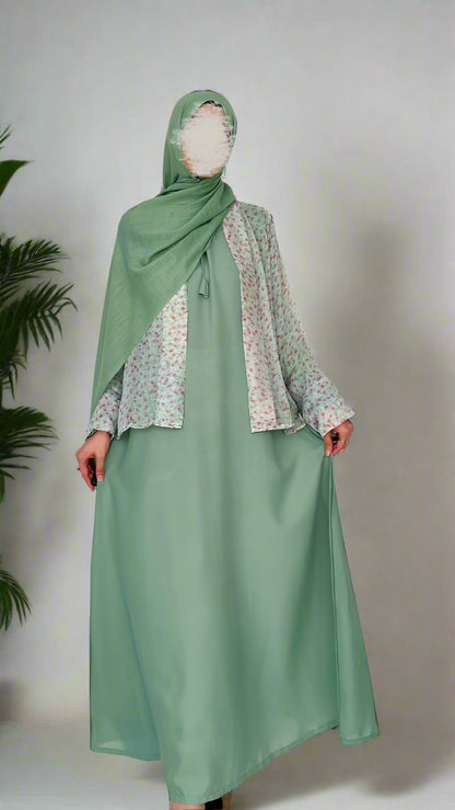 Person wearing a green dress with a floral patterned top against a white background