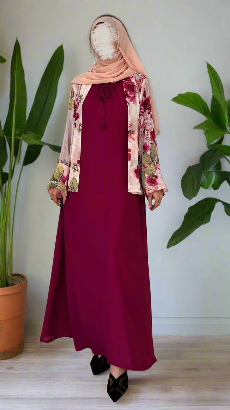 Mannequin wearing a burgundy dress with a floral jacket and matching hijab on a white background