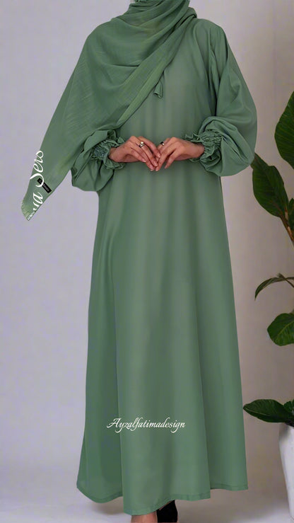 Green abaya dress worn by a person on a white background