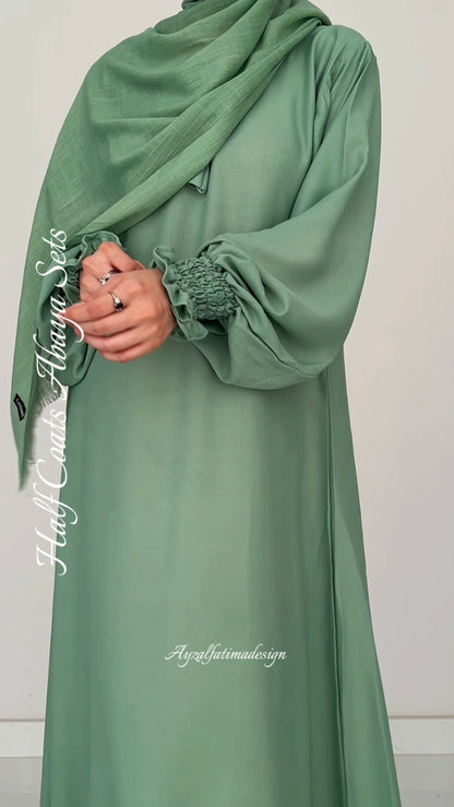 Green abaya with ruffled sleeves on a white background