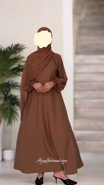 Brown dress with matching hijab on a plain background