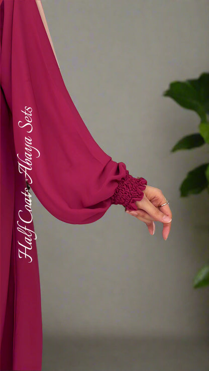 Magenta long-sleeve garment with brand name on a light gray background