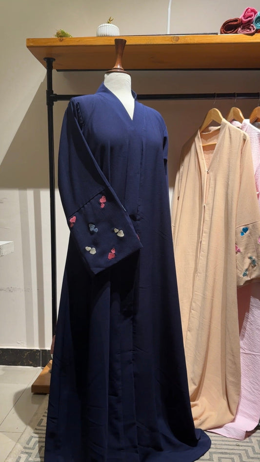 Navy blue dress with floral embroidery on a mannequin against a neutral background