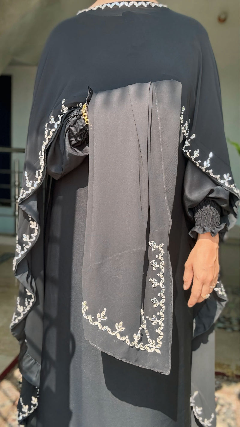 Black and gray traditional outfit with intricate white embroidery.