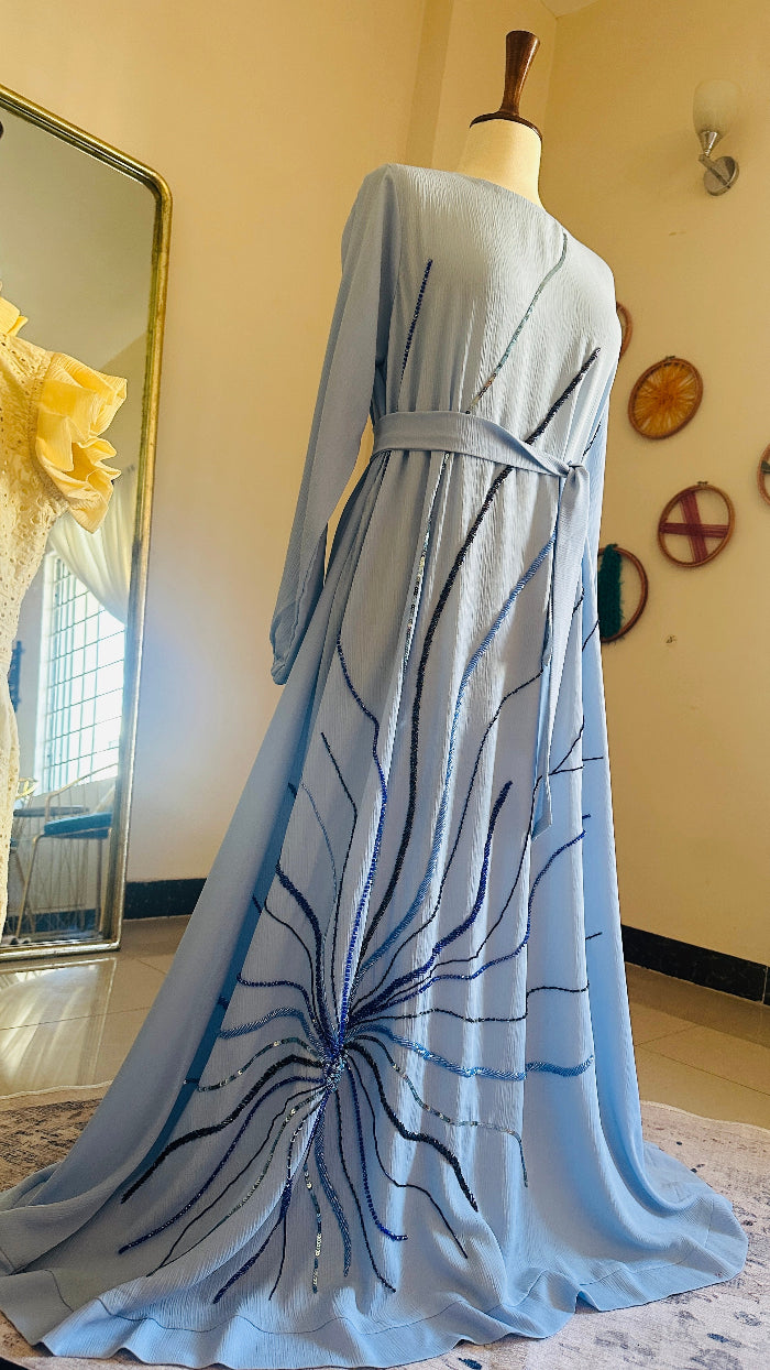 Blue dress with black abstract patterns on a mannequin in a room with decorative mirrors.