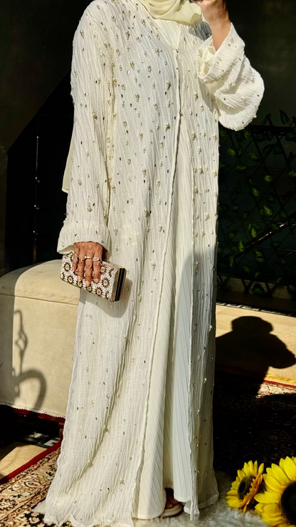 Woman in a white traditional outfit taking a selfie outdoors.