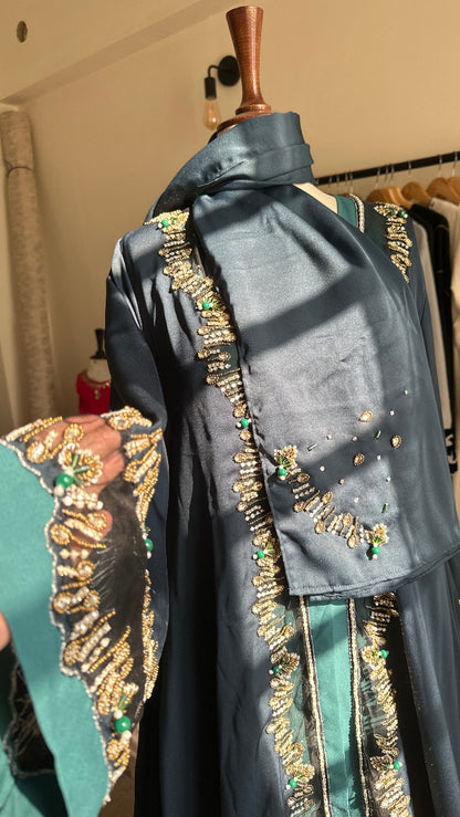 Decorative umbrella with gold and green embellishments on a wooden surface.