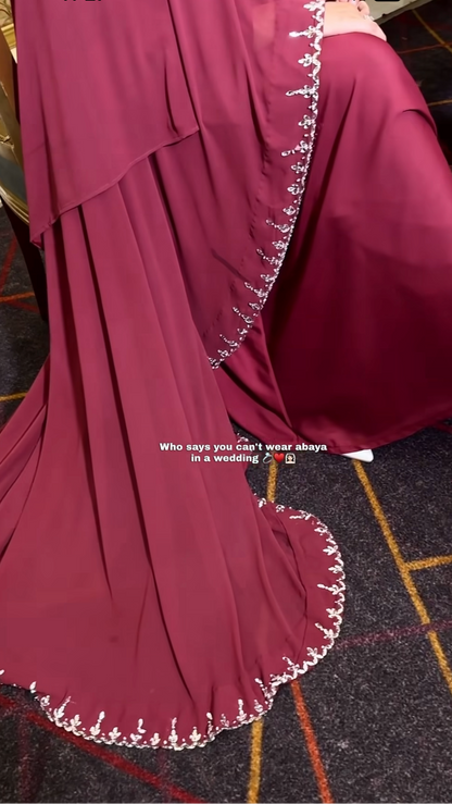 Maroon abaya with white embroidery on a tiled floor