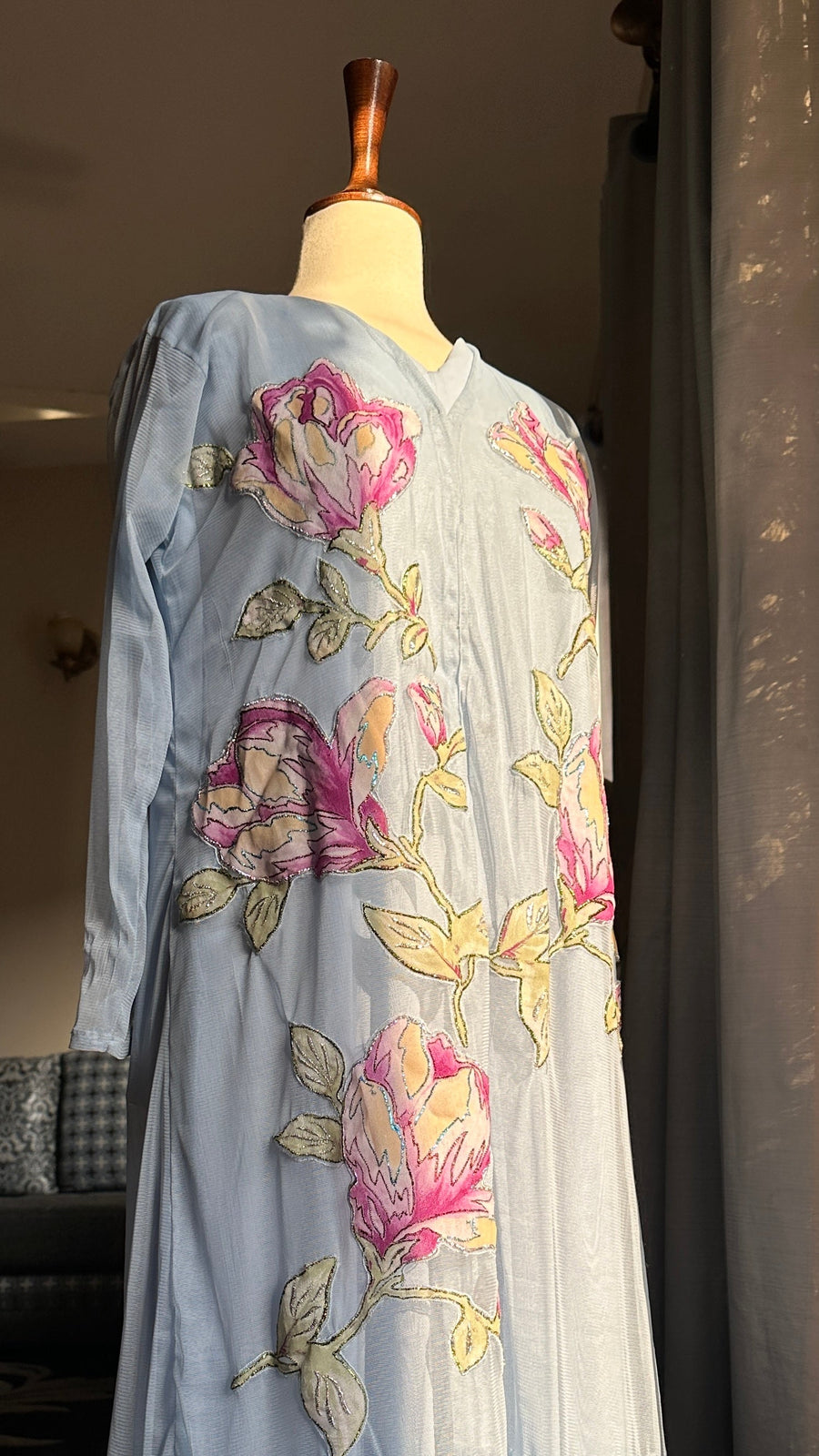 Light blue embroidered dress on a mannequin against a neutral background