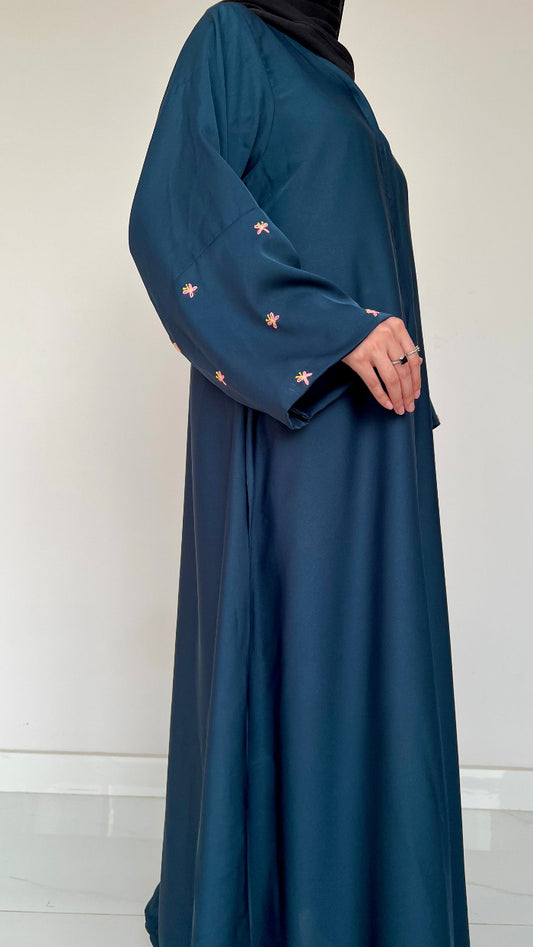 teal blue dress with floral embroidery on sleeves against a white background