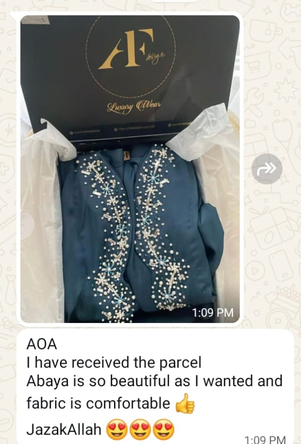 Blue abaya with white embroidery in a branded box