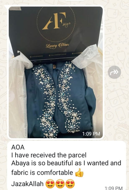 Blue abaya with white embroidery in a branded box