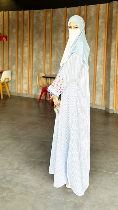 Person wearing a white abaya in a modern restaurant setting