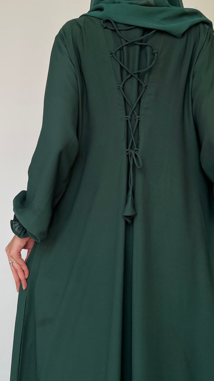 Green abaya with lace-up back on a plain background