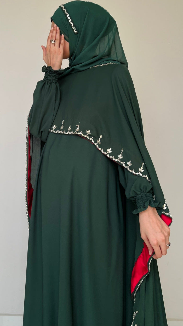Green abaya with embroidery on a plain background