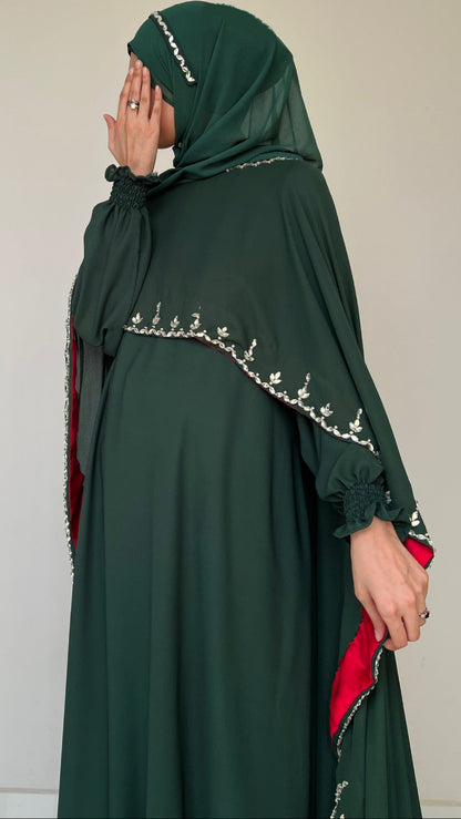 Green abaya with embroidery on a plain background