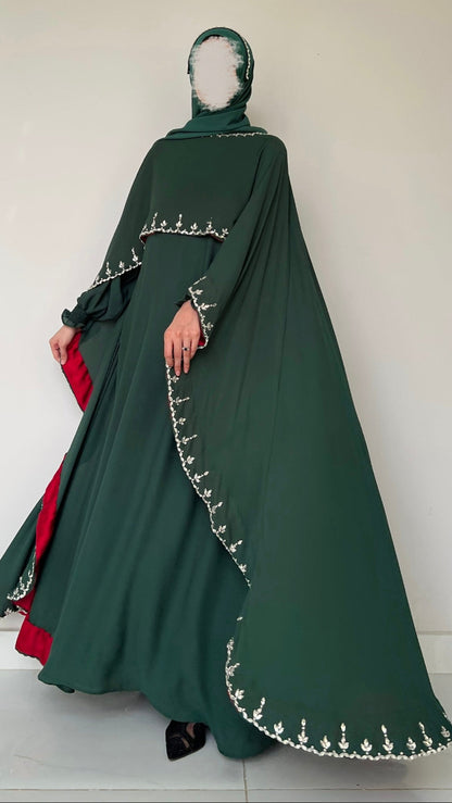 Green abaya with white embroidery on a plain background