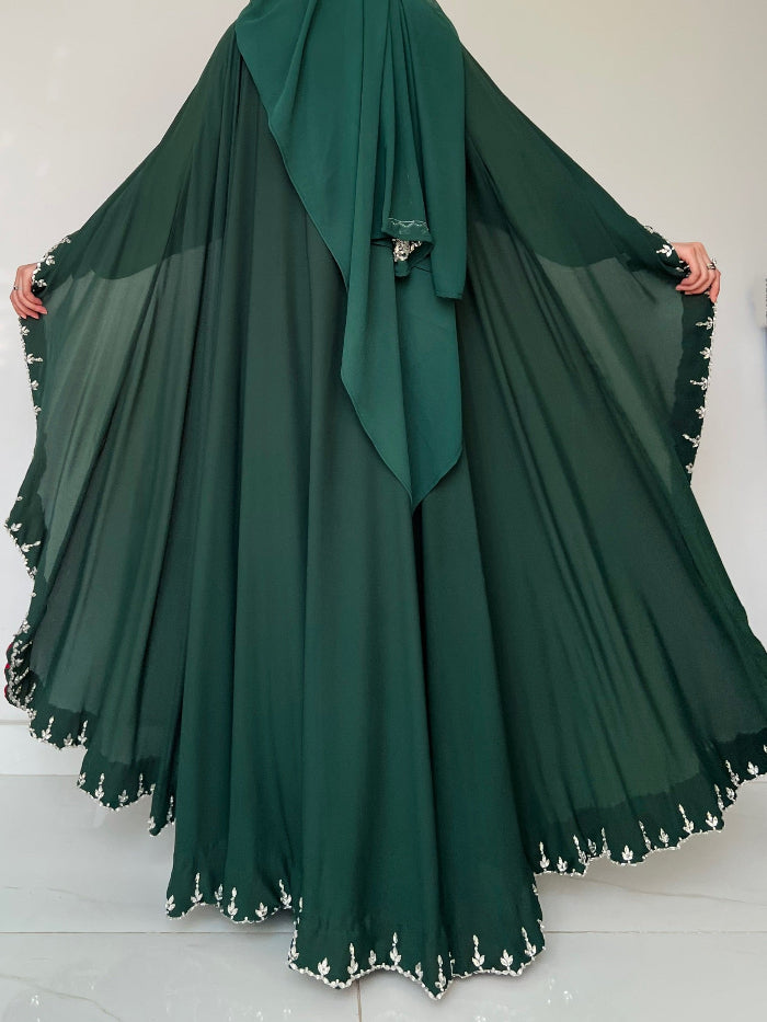 Green abaya with white trim on a white background